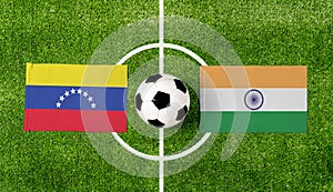 Top view soccer ball with Venezuela vs. India flags match on green football field