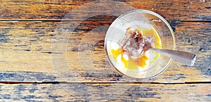 Top view of Soft-boiled eggs with tea spoon on brown wooden background or table with copy space