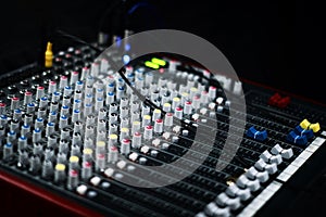 Top view of sound music mixer control panel in the event hall. Professional audio mixing console with faders and adjusting knobs.