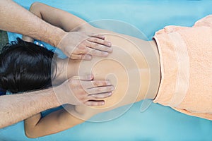 Top view. Spa therapy on a blue background. Beautiful asian woman having massage in beauty salon.