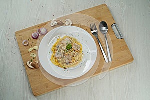 Top view of spaghetti carbonara on a cutting board