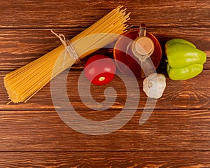 top view of spaghetti pasta with tomato garlic pepper and melted butter on wooden background with copy space