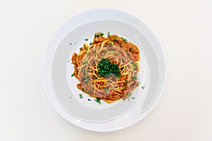 Top view of Spaghetti Sauce with Ground Beef in white bowl on white tablecloth with silver spoon
