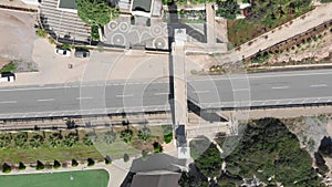 Top view of speed highway with cars along coastline with palms. Aerial drone view of asphalt car road at seashore