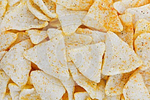 Top view of spiced and salted tapioca or cassava chips in triangle shape texture for background