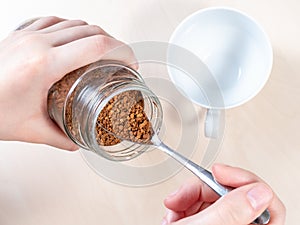 Top view of spoon in glass jar with instant coffee