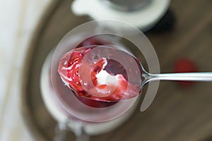 Top view of a spoon of yogurt with jam with a blurry background