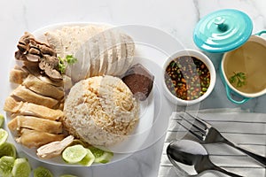 Top view Steamed chicken rice with chilli sauce and soup on white table background. Asia foods concept