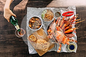 Top view of Steamed Giant Mud Crabs, Grilled Prawns Shrimps, Crab Fried RIce, Pepper and Garlic Soft-Shell Crab, Crispy Catfish.