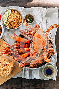 Top view of Steamed Giant Mud Crabs, Grilled Prawns Shrimps, Crab Fried RIce, Pepper and Garlic Soft-Shell Crab, Crispy Catfish
