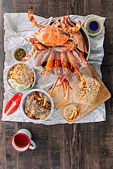 Top view of Steamed Giant Mud Crabs, Grilled Prawns Shrimps, Crab Fried RIce, Pepper and Garlic Soft-Shell Crab, Crispy Catfish.