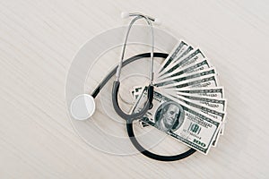 top view of stethoscope and dollar banknotes on table in clinic health