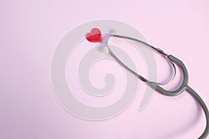 Top view Stethoscope and red heart on pale pink isolated background with  copy space for text. Close up, top view. Medical equipme