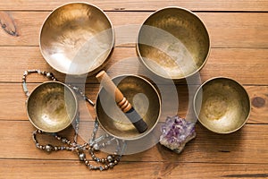 Top view of a still life with bronze singing bowls on a wooden table