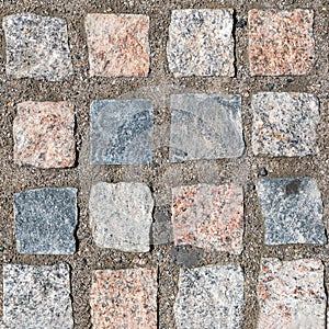 Top view on stone road. Abstract background of cobblestone pavement closeup. Brown texture of paving stone track