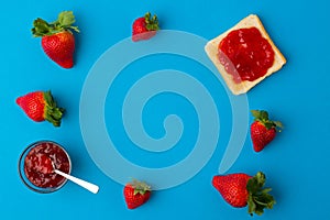 A top view of the strawberry jam-filled bread and strawberry fruit isolated on blue