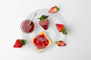 A top view of the strawberry jam-filled bread and strawberry fruit isolated on white