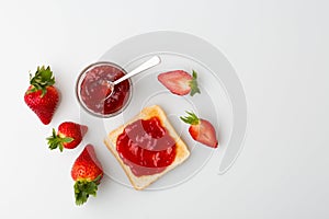 A top view of the strawberry jam-filled bread and strawberry fruit isolated on white