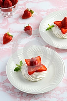 Top view strawberry meringue nests with mint on a plate