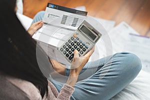 Top view of stressed young asian woman calculating monthly expense and checking credit card bills invoice