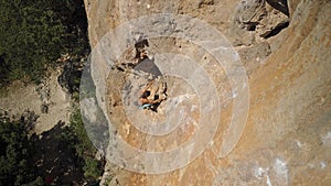 top view strong handsome man rock climber climbs up sunny limestone wall by challenging route. outdoor activity, active