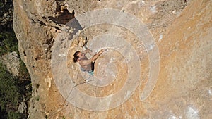 top view strong handsome man rock climber climbs up sunny limestone wall by challenging route. outdoor activity, active