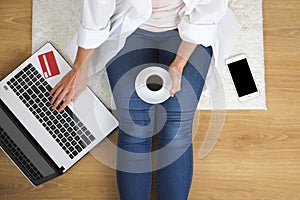 Top view of student girl surfing internet, online shopping on laptop and cellphone, holding debit / credit card, entering promo co