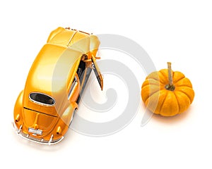 Top view studio shot small orange toy car with mini pumpkin isolated on white