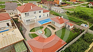 Top view of suburban house with pool, green garden and terrace. Large farm country house