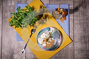 Top view of a summer breakfast. White ice cream, green foliage, jar of fruity drink on a table background. Light snacks.