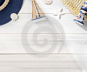 Top view summer rustic blue lighthouse and seashell decorate on white wooden table with sunlight shade