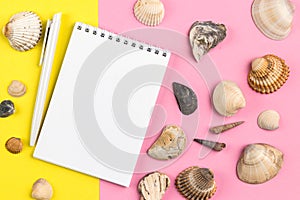 Top view Summer vacation pink and yellow mockup: photo frame, pen, seashells on yellow background. Travel, beach concept. Space