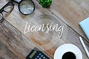 Top view of sunglasses,magnifying glass,plant,notebook,pen, a cup of coffee and calculator on wooden background written with