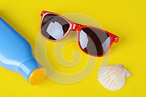 Top view of sunglasses, shells, starfish and sunblock