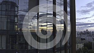 Top view of sunset reflection in windows of business high-rise. Stock footage. Modern skyscraper with glass windows and