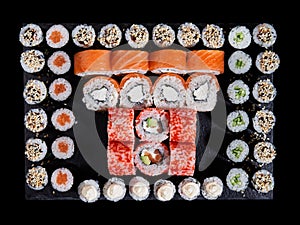 Top view of sushi rolls philadelphia and california placed in a square of small maki rolls.