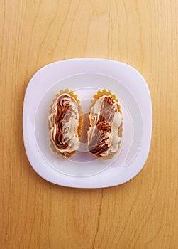Top view of sweet cakes with cream filling on a white plate