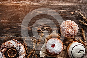 Top view of sweets donuts and pretzel or cracknel and lemon slice dry on wooden background with copy space photo