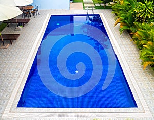 Top view of swimming pool with clear blue water in resort, outdoor architecture