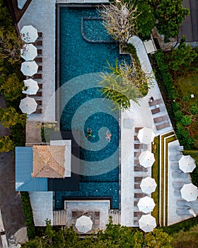 Top view swimming pool, drone view pool, couple in swimming pool during vacation