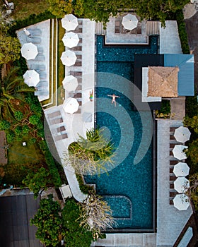 Top view swimming pool, drone view pool, couple in swimming pool during vacation in Thailand