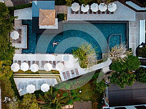 Top view swimming pool, drone view pool, couple in swimming pool during vacation in Thailand