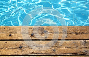 Top view of swimming pool and wooden deck background.