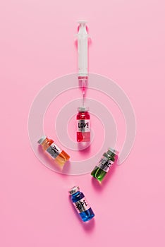 top view of syringe and bottles with love hope joy and peace vaccine signs