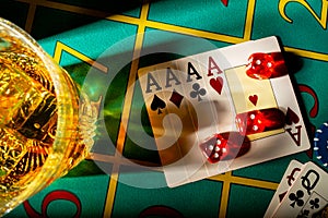 Top view of table in casino with glass of whiskey and set of four aces. Close up of a dark gambling table with booze