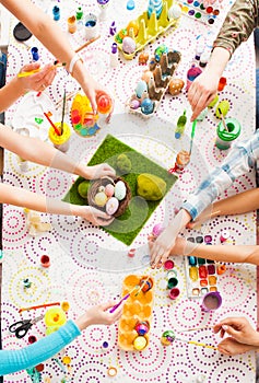 Top view table with Easter decoration and kids hands