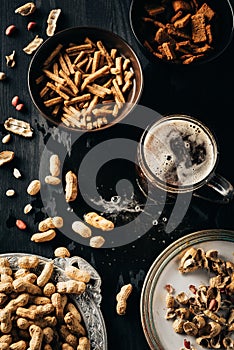top view of table set with snacks and glass of beer on dark