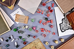 Top view of tabletop roleplaying flat lay with RPG and game dices, rule book, notes and treasure map