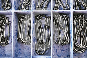 Top view of tackle box with fishing hooks. Fishing hooks in box sections. Macro of fishhooks photo
