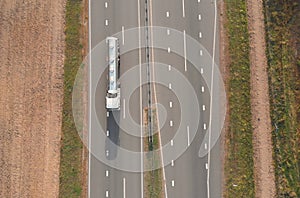 Top view of a tanker truck that moves along an asphalt road.